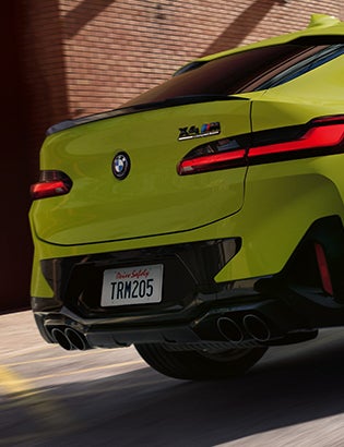 Detail shot of the quad exhaust system on a BMW X4 M in Sao Paolo Yellow.
