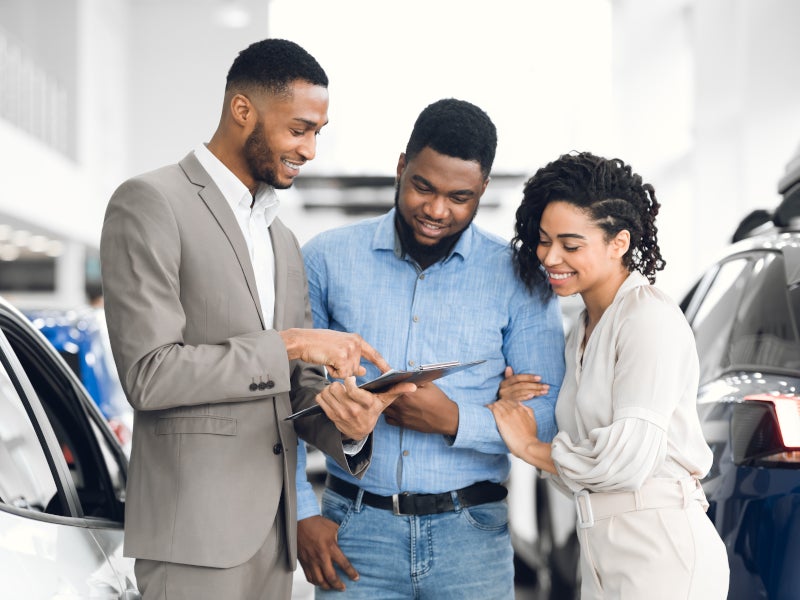 Customers reviewing vehicle options with sales consultant