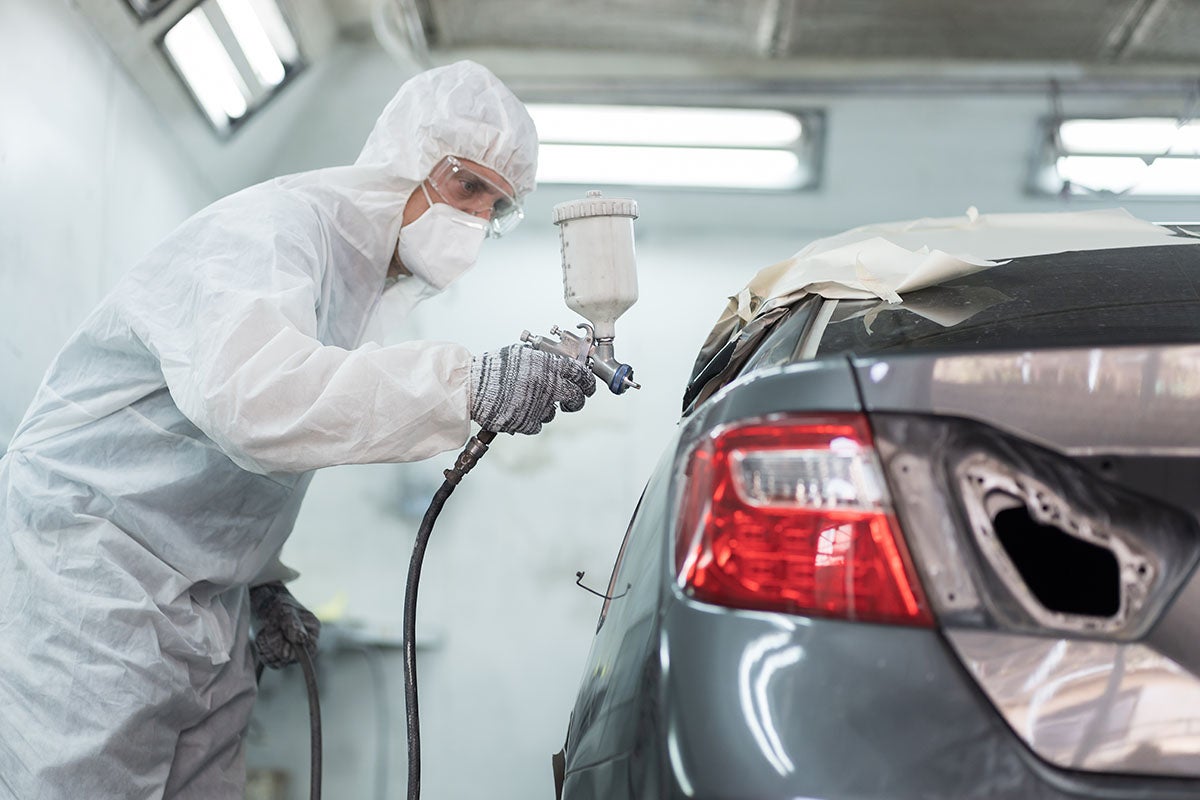 vehicle being refinished or repainted inside what appears to be an automotive paint booth or body repair workshop